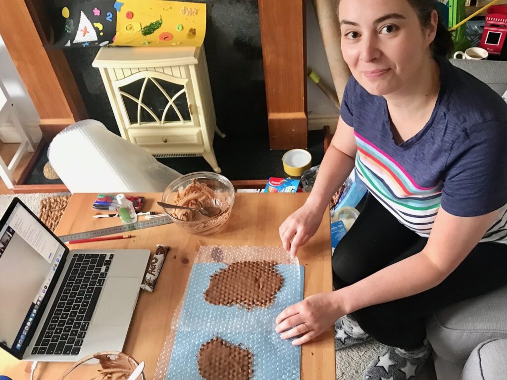 Becky demonstrating melted chocolate spread onto bubble wrap.