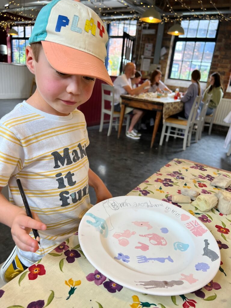 Becky's son decorates his own plate in the studio.