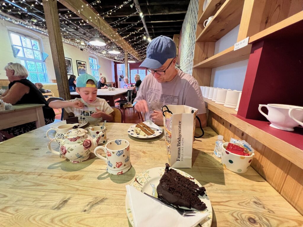 With Becky's chocolate cake in the foreground, Becky's husband and son enjoy cake in the Emma Bridgewater cafe.