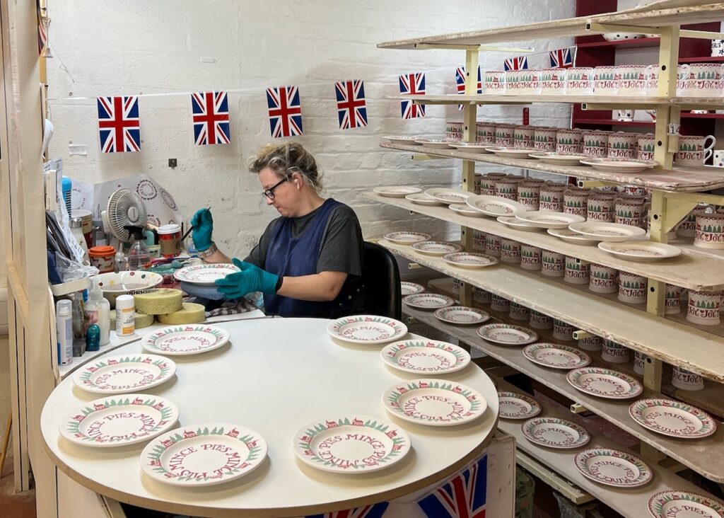 A worker adds hand painted touches to some Christmas side plates.