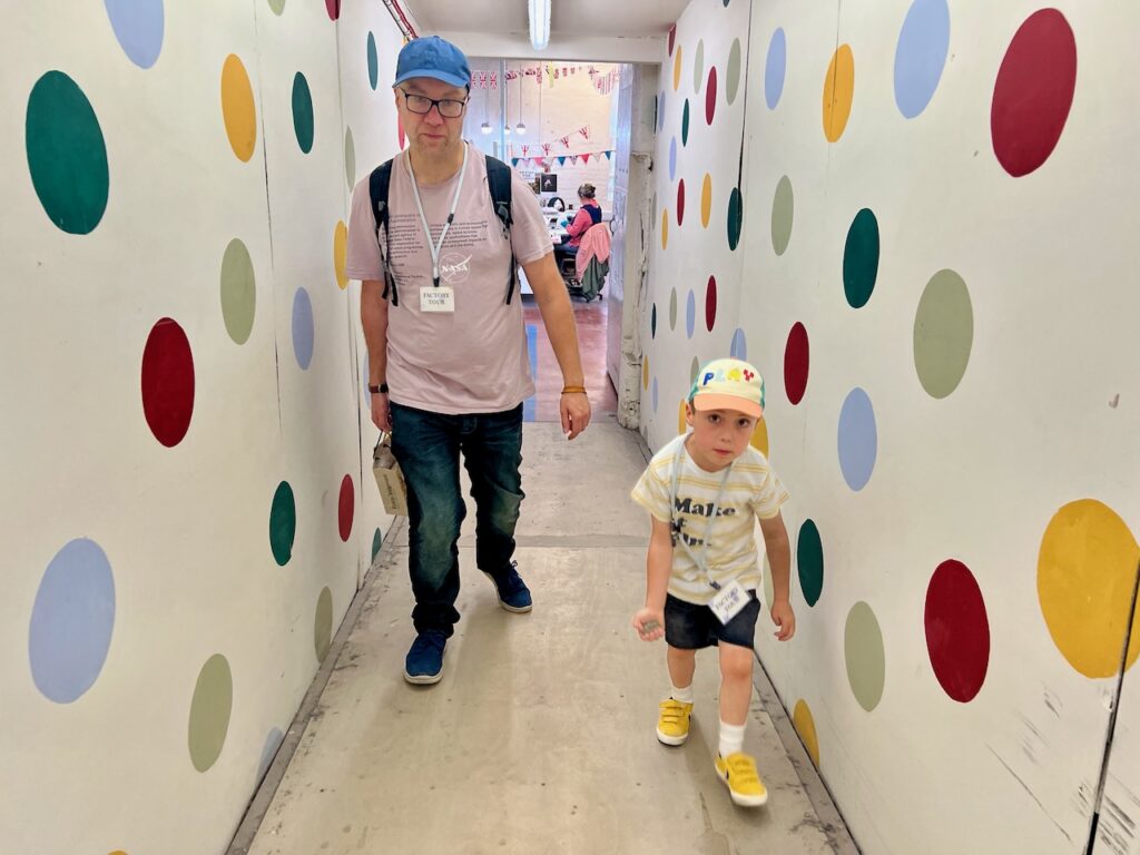 Becky's husband Sean and son Reuben walk through a spotty decorated corridor.